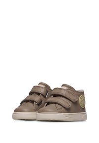 Scarpe in pelle sintetica marrone con due cinturini in velcro regolabili e una suola testurizzata color crema. Dettaglio del logo circolare sul lato esterno.