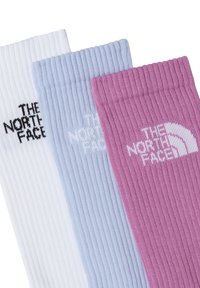Tres pares de calcetines acanalados en blanco, azul claro y rosa, con el logo "THE NORTH FACE" en colores contrastantes en cada par.