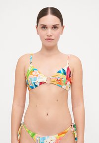 Flerfarget bikinimal med blomstermønster og abstrakte former. Den har en trekantet bralette med en sentral sirkulær aksent og justerbare stropper.