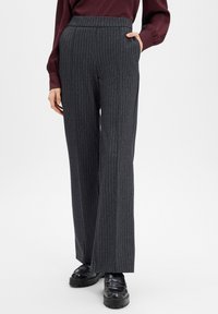 Wide-legged trousers in dark gray fabric with a pinstripe pattern. Features a high waistband and side pockets. Paired with black shoes.