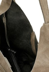 Sac fourre-tout en daim beige avec un dessus ouvert. L'intérieur comprend une poche zippée noire. Texture douce et design simple.