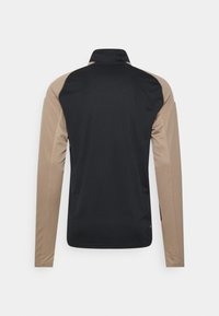 Long-sleeve shirt with a black back and tan sleeves. Made of smooth fabric, features a stand-up collar and a simple design with no patterns.