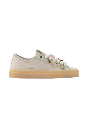 Sneaker beige chiaro modello basso con suola in gomma e lacci bianchi soffici adornati con piccoli accessori colorati a forma di ciondolo.
