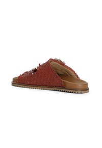 Papuci roșii împletiți, cu o talpă plată bej, având accente decorative și un design cu degete deschise, potriviți pentru purtarea casuală.