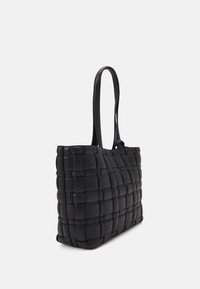Sac fourre-tout en cuir tissé noir avec deux longues poignées, présentant un motif en grille et une forme rectangulaire. Texture lisse, sans matériel visible.