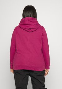 Fuksjowa bluza z kapturem z mieszanki bawełny, z kieszenią kangurką, ściągaczami przy rękawach oraz luźnym krojem. Widziana z tyłu.
