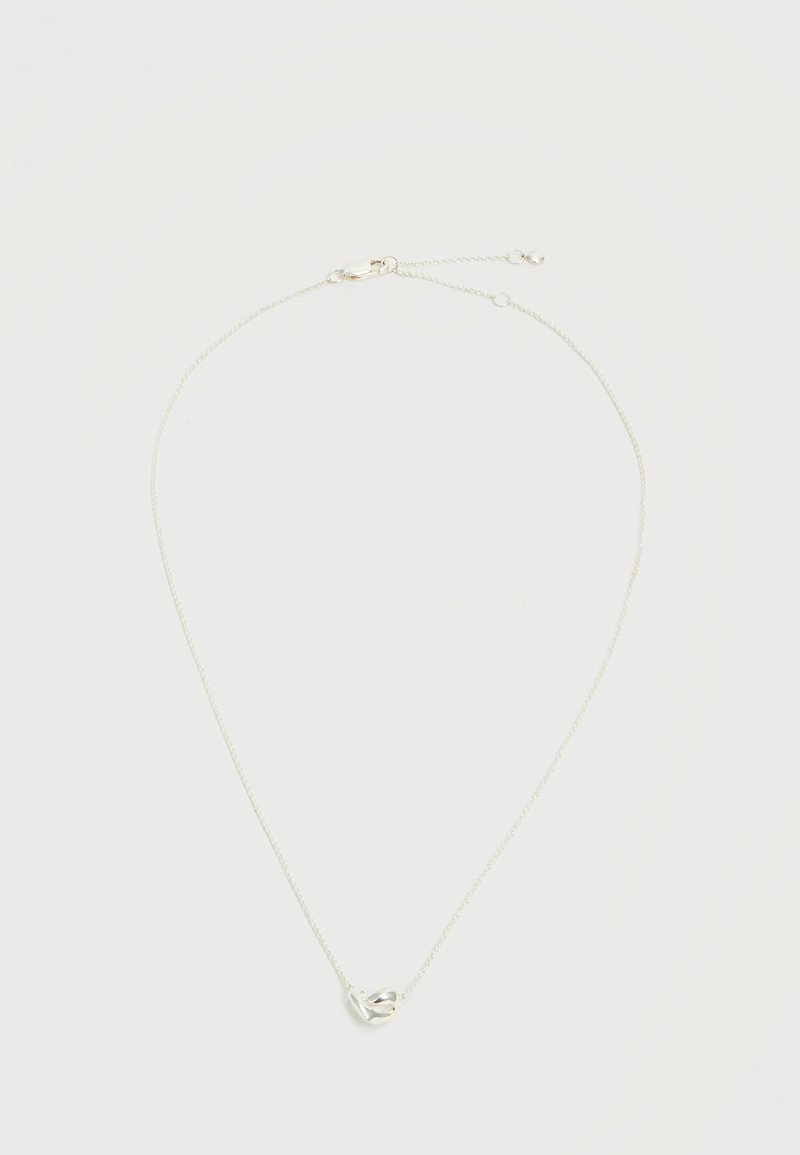 Collier délicat en chaîne argentée avec un petit pendentif abstrait en forme de cœur et une fermeture à mousqueton avec des maillons réglables.