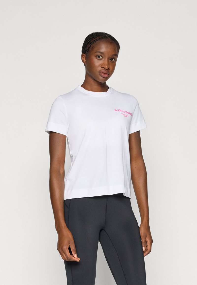 Bílá tričko s krátkým rukávem a kulatým výstřihem, se růžovým textem "BJÖRN BORG" na levé části hrudi. Měkký bavlněný materiál, volnější střih.