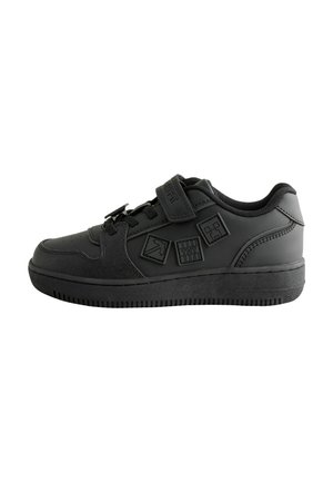 Fekete alacsony szárú sneaker tépőzáras pánttal, fekete fűzőkkel és három Minecraft témájú négyzet alakú folttal az oldalon.