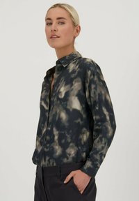 Langarm overhemd in zwart met een grijs en crèmekleurig tie-dye patroon. Het shirt heeft een klassieke kraag en een ontspannen pasvorm, gemaakt van gladde stof.