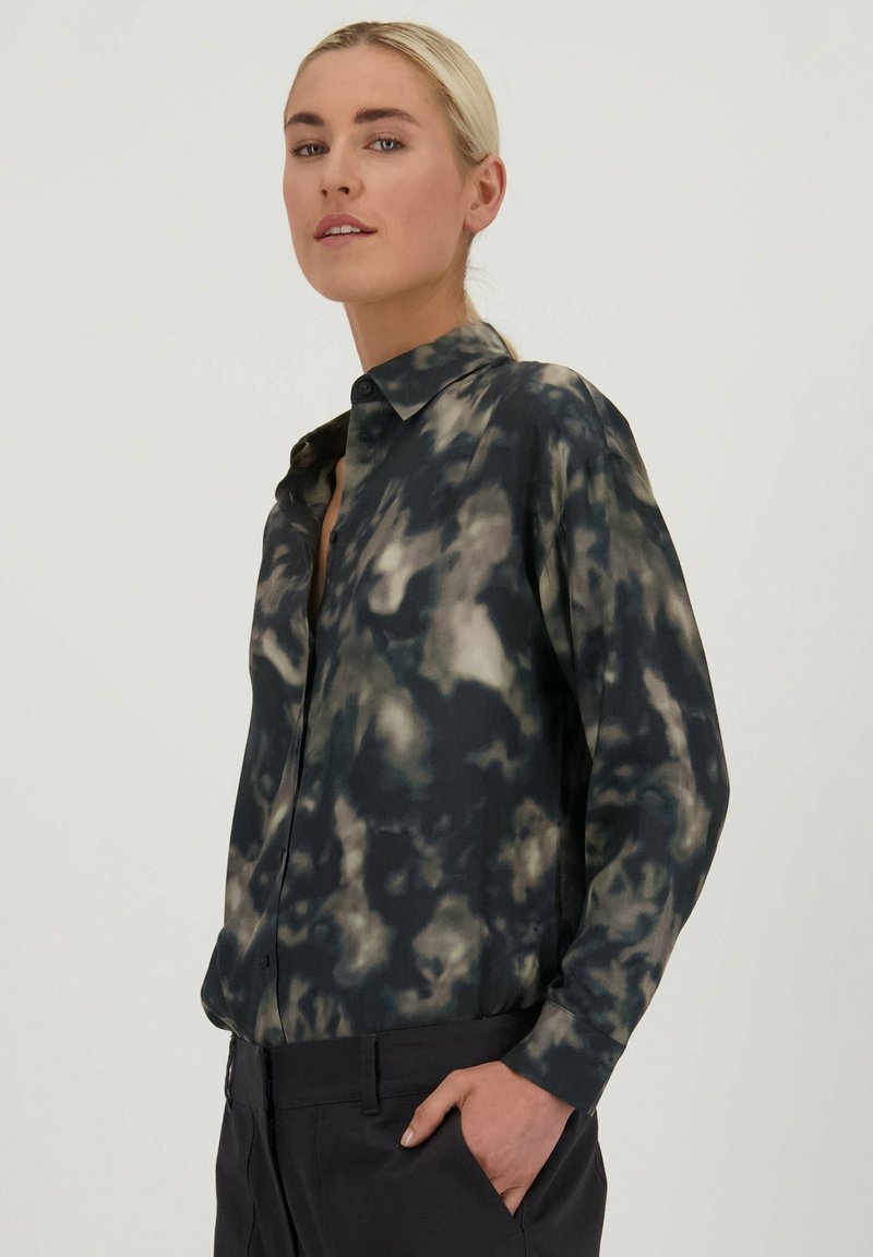 Langarm overhemd in zwart met een grijs en crèmekleurig tie-dye patroon. Het shirt heeft een klassieke kraag en een ontspannen pasvorm, gemaakt van gladde stof.