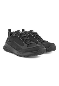 Zwarte sportschoenen met een textuurafwerking, meshpanelen en contrasterende witte veters. Voorzien van een robuuste zool en een trekhaak voor gemakkelijk aan- en uittrekken.