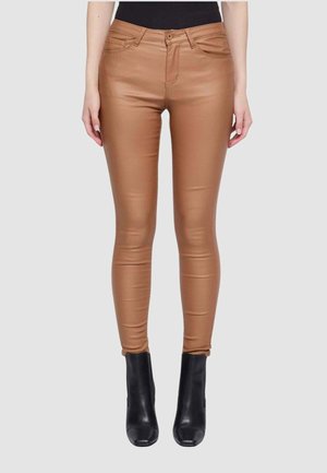 Pantaloni skinny in finta pelle marrone, con un classico design a cinque tasche, texture liscia e abbinati a stivali neri alla caviglia.