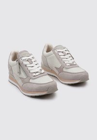 Zapatillas ligeras con una combinación de cuero blanco y gamuza gris. Cuentan con un diseño de cordones y un jersey lateral para facilitar su uso.