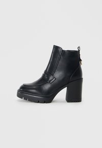 Bottines en cuir noir avec un talon épais, texture lisse, détail de bande décorative et languette arrière pour un enfilage facile.
