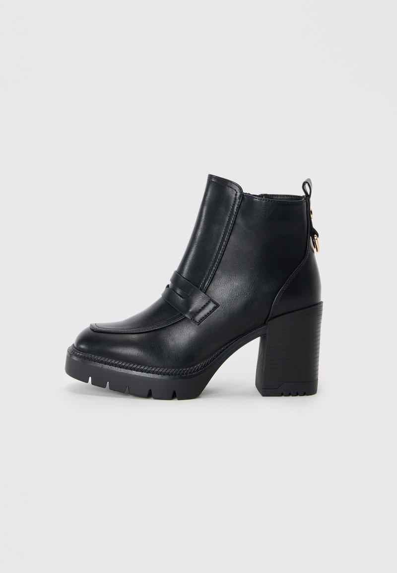 Bottines en cuir noir avec un talon épais, texture lisse, détail de bande décorative et languette arrière pour un enfilage facile.