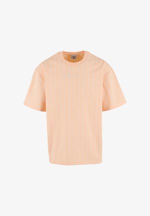 T-shirt à manches courtes couleur pêche avec de fines rayures blanches verticales et un petit logo signature brodé sur la poitrine.