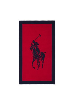 Tapis rectangulaire rouge avec une bordure bleu marine et une silhouette bleu marine d'un joueur de polo à cheval, brandissant un maillet.