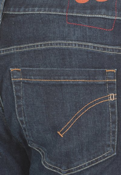 Jeans in denim di colore blu scuro, con cuciture arancioni, una tasca posteriore con un design curvo e cuciture rosse a contrasto lungo la vita.