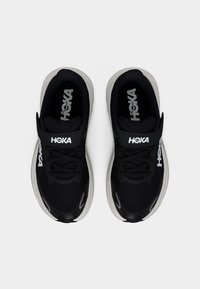 Μαύρα και γκρι αθλητικά παπούτσια HOKA με κορδόνια και λουράκι με βέλκρο, εμφανιζόμενα από πάνω σε λευκό φόντο.