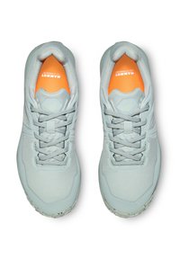 Ljusgråa träningsskor med texturerat material, vadderad krage och orange detaljer på innersulan. Har snörning och förstärkt tå.