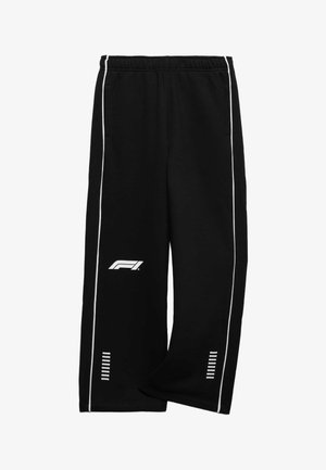 Sorte sweatpants med vide ben med hvide kantstriber langs siderne, elastisk linning, F1-logo på venstre lår og reflekterende striber nær anklerne.
