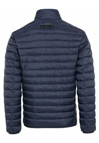 Marineblauwe gewatteerde jas met een geplooid ontwerp, hoge kraag en geribbelde manchetten. Glad, lichtgewicht materiaal met een subtiele logo op de achterkant.