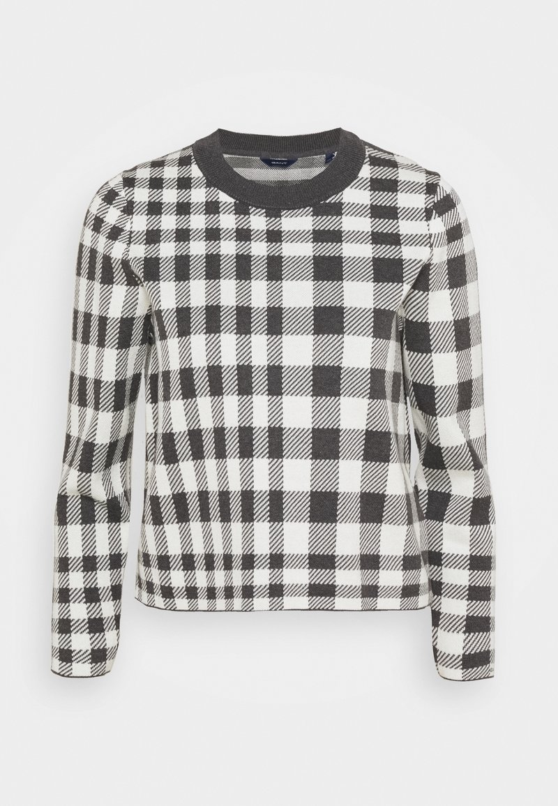 Pull à carreaux noir et blanc avec un col rond côtelé, des manches longues et une coupe ajustée. Le motif présente des carrés et des rayures alternés.