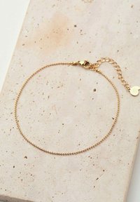 Pulsera chapada en oro con un delicado diseño de cuentas, con un cierre de langosta y una cadena ajustable para personalizar la longitud.