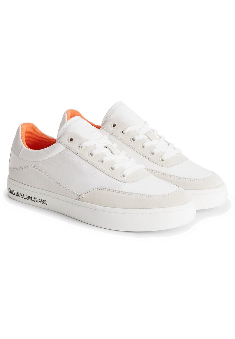 Sneakers bianche con una finitura in pelle liscia e scamosciata. Presentano un rivestimento interno arancione, lacci bianchi e un marchio nero lungo il lato.