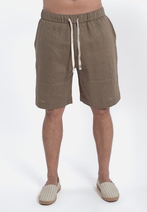 Liniowe szorty w ziemistym brązie z elastycznym paskiem w talii i sznurkiem, z bocznymi kieszeniami i luźnym krojem. Akcentowane kremowymi trokami.