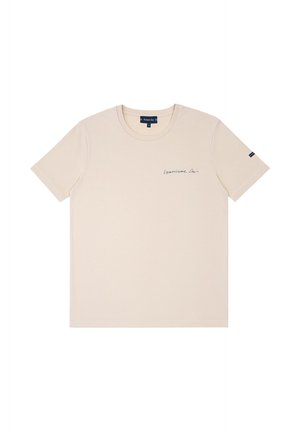 T-shirt beige à manches courtes et col rond avec un petit texte bleu marine « Commissaire Lapin » sur la poitrine gauche et une étiquette bleu marine sur la manche gauche.
