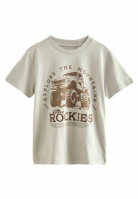 Vaaleanharmaa puuvillateeppari, jossa on pyöreä pääntie. Teepaidassa on ruskea painatus monsteriautosta sekä tekstit "Tutki vuoria" ja "The Rockies."