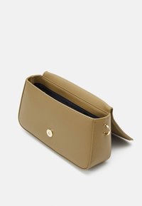 Prostokątna torba z jasnobrązowej skóry o gładkiej fakturze, zapięcie na złoty zatrzask i niebieskie wnętrze. Posiada boczną pętlę do przypięcia paska.