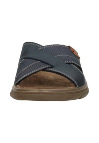 Donkerblauwe sandaal met gekruiste geperforeerde banden, bruin suède inlegzool en een rubberen zool. Kenmerkt lichte bruin stiksel en een kleine accent.