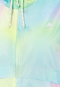 Jasny, pastelowy hoodie w odcieniach tęczy z białymi sznurkami ściągającymi oraz białym logo górskim Burton na prawej stronie klatki piersiowej.