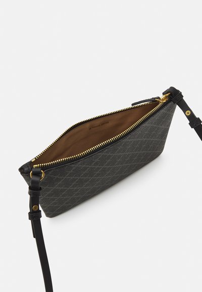Pochette à motifs gris avec une fermeture éclair dorée. Dotée d'un intérieur beige et d'une anse en cuir noir avec des accents en or.