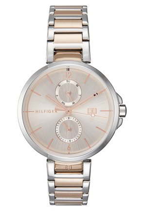 Tommy Hilfiger armbåndsur med sølv- og rosaguldfarvet metalrem, rund sølvfarvet urskive, under-dials med dag og dato samt minimalistiske timemarkeringer.