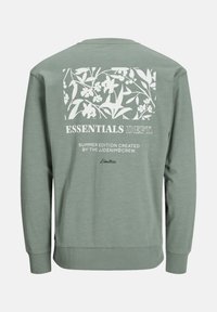 Grüner Sweatshirt mit langen Ärmeln, Rundhalsausschnitt und einem weißen Blumenmotiv auf der Rückseite mit dem Text "ESSENTIALS DEPT."