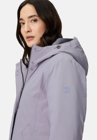 Licht lavendelkleurig gewatteerd jack met capuchon, ritssluiting aan de voorkant, drukknopen en een logo-accent op de mouw. Voorzien van gladde stof en een gestructureerde capuchon.