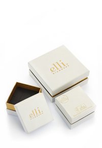 Hvide smykkeskrin med guld accenter, der har en tekstureret sort indvendig. Indeholder et større skrin og et mindre inderskrin.