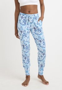 Pantaloni azzurri con un motivo floreale in blu navy e blu scuro. Presentano una vita con coulisse e tasche laterali, con una vestibilità affusolata.