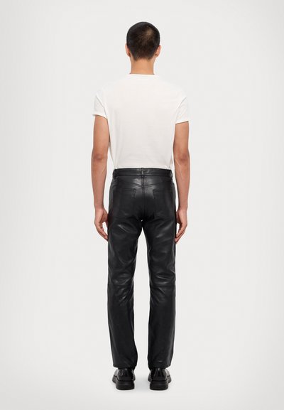 Zwarte leren broeken met een slim fit, met een gemiddelde taillehoogte, achterzakken en een gladde textuur. Draag ze met een eenvoudig wit T-shirt.