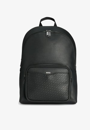 Czarna skórzana plecak o gładkiej fakturze, z przednią kieszenią na zamek z wzorem i podwójnymi zamkami u góry. Logo umieszczone na kieszeni.