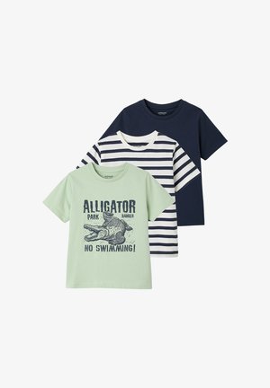 Drei Kinder-T-Shirts: hellgrün mit Alligator-Print und Text, weiß mit marineblauen Streifen und einfarbig marineblau.