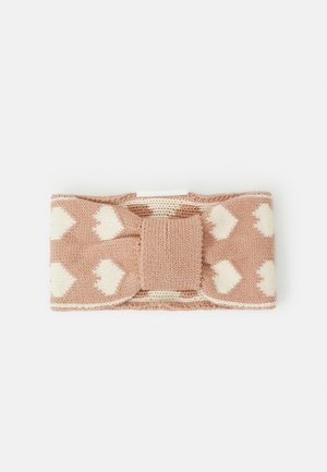 Accessoire capillaire tricoté avec une base rose clair et des motifs en forme de cœur blancs. Présente un nœud central avec un tricot texturé et des bords lisses.
