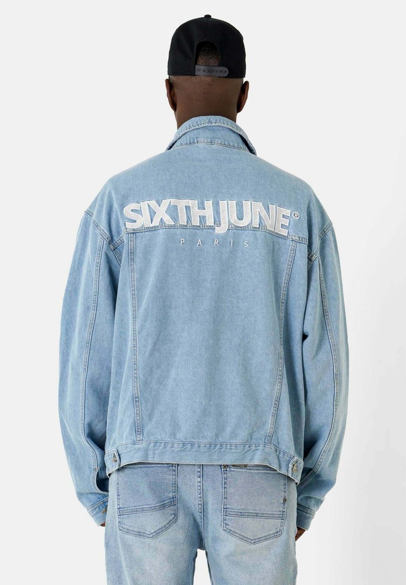 Veste en denim bleu clair à coupe carrée, avec les inscriptions brodées en blanc "SIXTH JUNE" et "PARIS" au dos, dotée de boutons et de poches latérales.