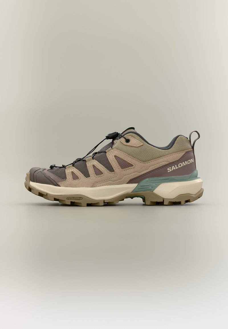 Παπούτσι πεζοπορίας Salomon χαμηλού κόψιμου σε μπεζ και καφέ χρώμα με πάνελ από δίχτυ, σύστημα ταχείας δέσης κορδονιών, υφή στη σόλα και λουράκι στο πίσω μέρος, εμφανιζόμενο σε πλευρική όψη.