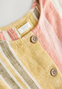 Robe en lin avec un col rond, ornée de rayures verticales rose, jaune et verte. Deux boutons marron décorent l'avant.