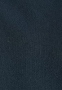Marineblauer Rippstoff mit feiner Textur, der vertikale Linien und eine weiche Oberfläche aufweist, geeignet für Bekleidungs- oder Polsteranwendungen.